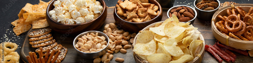 Assortment of salty snacks on dark background. Assortment of salty snacks on dark background.
