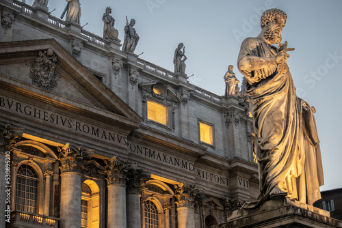 Figura na tle bazyliki św. piotra w rzymie wieczorem photo