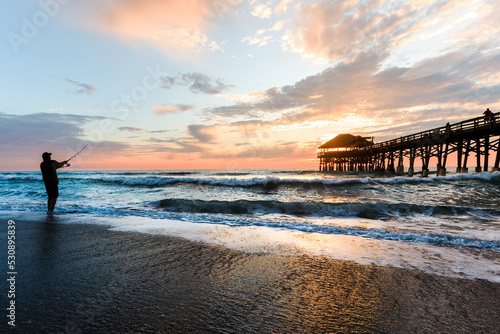 Fishing silhouette at the pier during sunrise