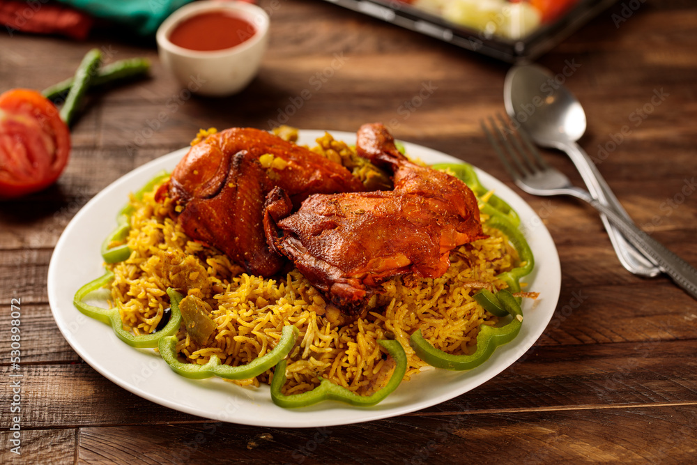 Chicken behari biryani with salad and tomato sauce served in a dish isolated on wooden table background side view of fastfood Chicken behari biryani with salad and tomato sauce served in a dish isolated on wooden table background side view of fastfood