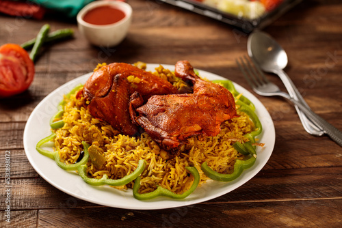 Chicken behari biryani with salad and tomato sauce served in a dish isolated on wooden table background side view of fastfood photo