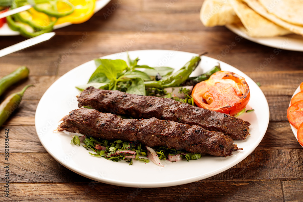 Beef Kebab with salad served in a dish isolated on wooden table background side view of fastfood
