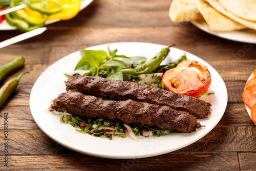 Beef Kebab with salad served in a dish isolated on wooden table background side view of fastfood