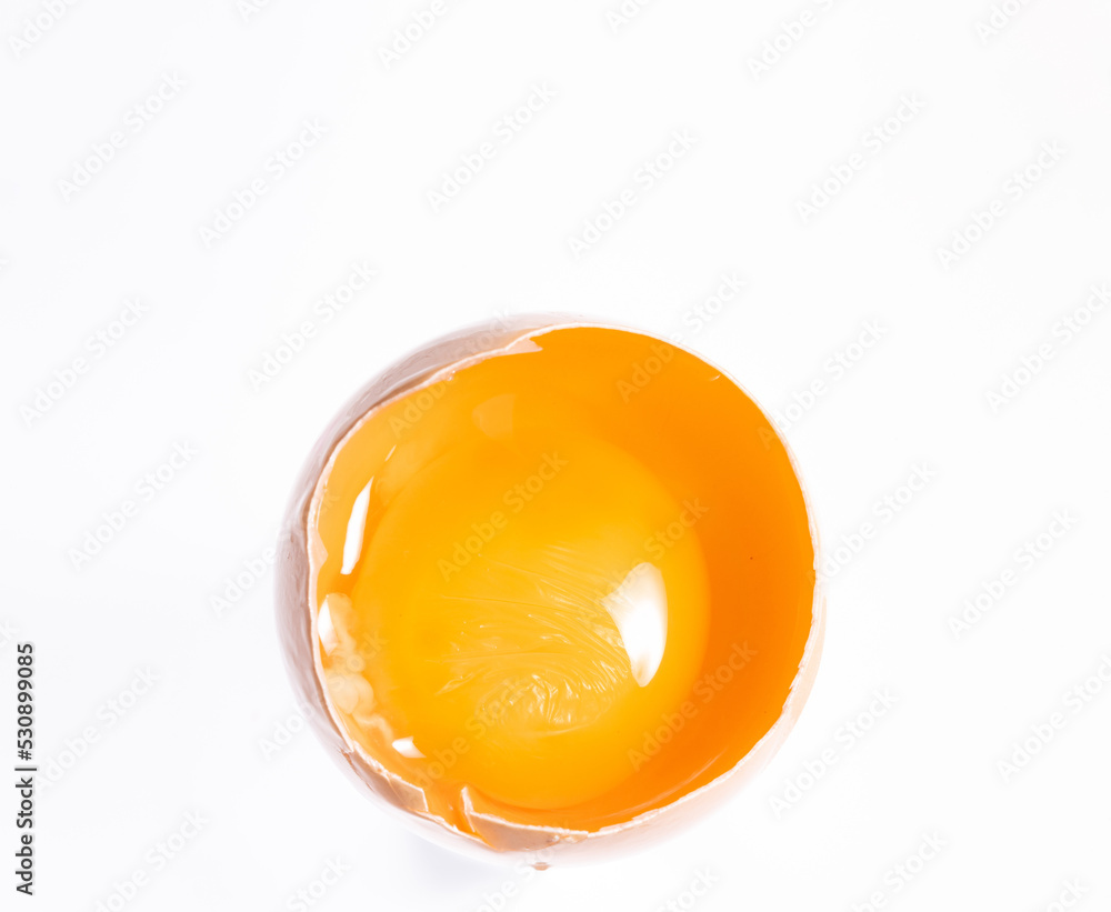 Egg yolk in a shell isolated on a white background. Egg yolk close-up. Broken chicken egg.