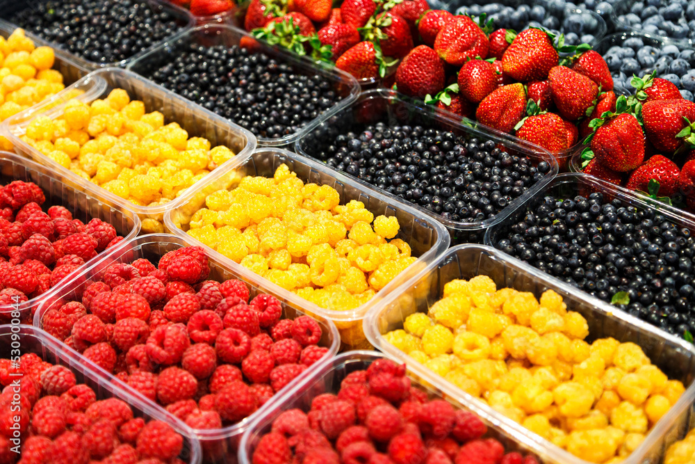 Colourful mix of different fresh berries at market. Raspberries, strawberries, blueberries and bilberries Colourful mix of different fresh berries at market. Raspberries, strawberries, blueberries and bilberries