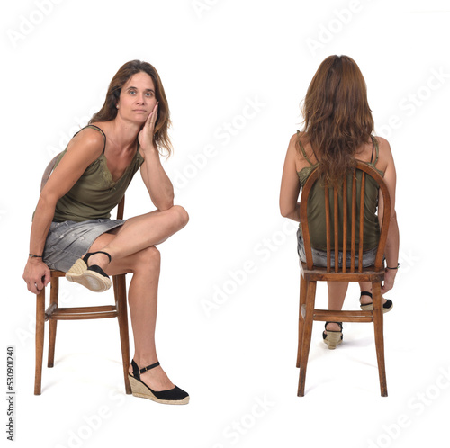 front and back view of a woman with denim skirt and spadrille sitting on chair on white background © curto