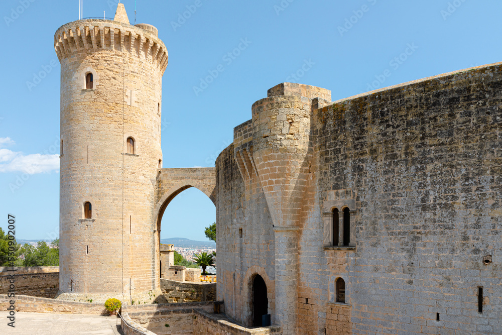 Castillo de Bellver, en Palma de Mallorca. Vista exterior de la muralla circular y la torre del homenaje, conel arco gótico que deja ver la ciudad al fondo. Mallorca, Islas Baleares, España.