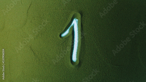Hand drawing Number One 1 Symbol in the Green Sand. Male hand writes a number on the green sand with backlight. It is a series from 0 to 10. Top view 4k resolution