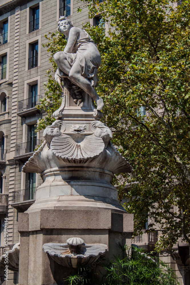 Obraz premium An exterior view of the historical Diana Fountain stands in the central section of Barcelona's Gran Via in Catalonia, Spain, Europe. Tall marble statue of the Roman goddess Diana the huntress.