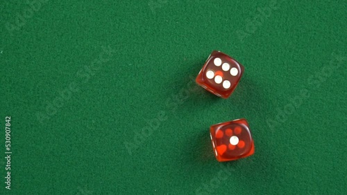 Two red roll dices and stops on the table with 6 and 1 in slow motion.