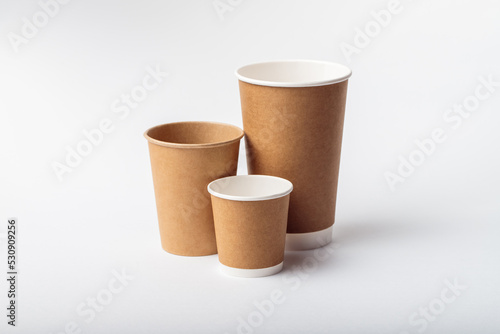 Three empty paper cup for coffee made from biodegradable brown paper on a white background. Isolated for mock up