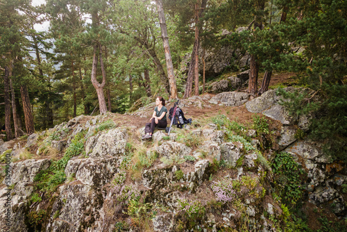 Aerial shot of Hiker on top of mountain, woman sitting on the edge of the rock
