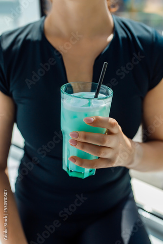 Fitness girl holding a glass with sports nutrition drink
