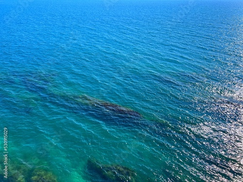 Beautiful blue sea with shiny glittering ripples water aerial view.