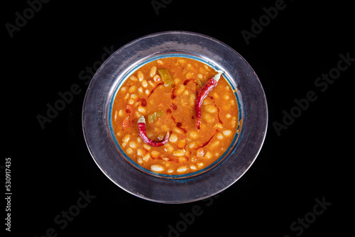 Haricot bean. Dried beans,white beans in tomato sauce in a copper bowl dry chili pepper on the plate.