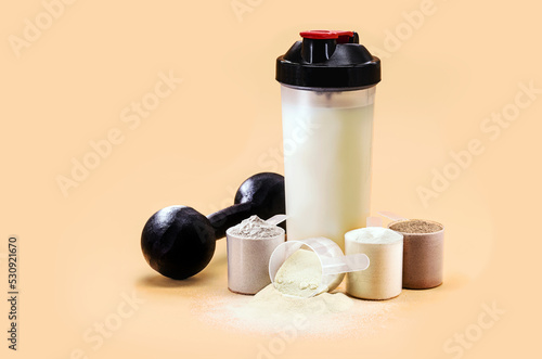 whey or casein shake, whey smoothie with protein chocolate bar, weight training dumbbell on the side, creatine blend for muscle mass gain, copyspace photo