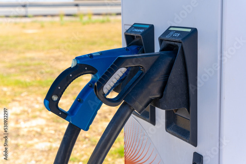 Electric car chargers at a gas station, with a parking space. ecological mobility