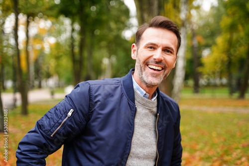Portrait of happy handsome man  smiling to the camera during outdoor autumn walk.