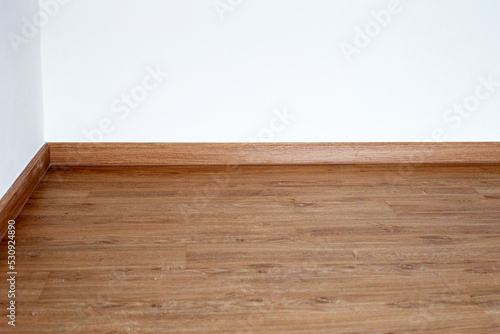 Laminate wood floor with blank white wall