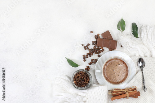 Cozy home table with cappuccino coffee,coffee beans cinnamon,chocolate,healthy breakfast with ingredients, hello autumn concept, hygge style, modern coffee shop advertisement, selective focus,