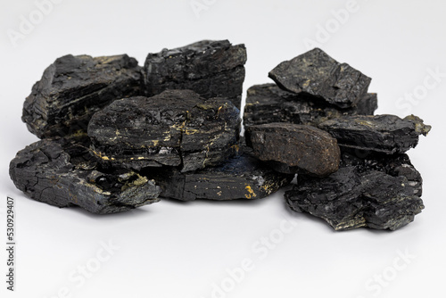 Black coal lumps isolated on white background. Fossil fuel, air pollution and coal mining industry concept.
