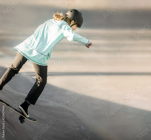 young teen girl having fun and practicing in a skate park, urban background, healthy active lifestyle