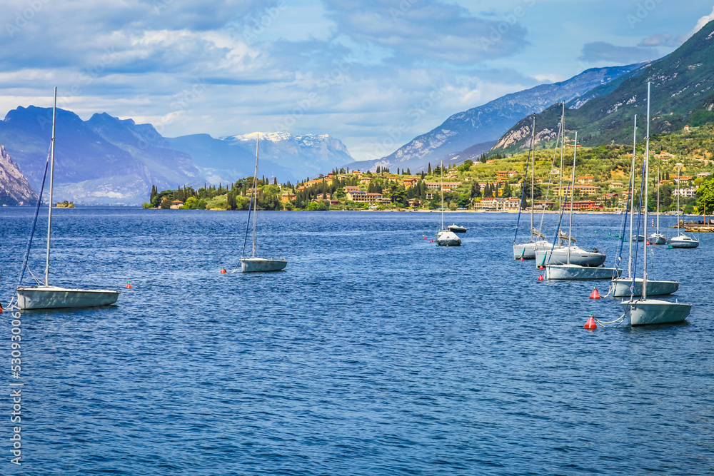 Idyllic lake Garda coastline in Malcesine with sailboats, Northern Italy