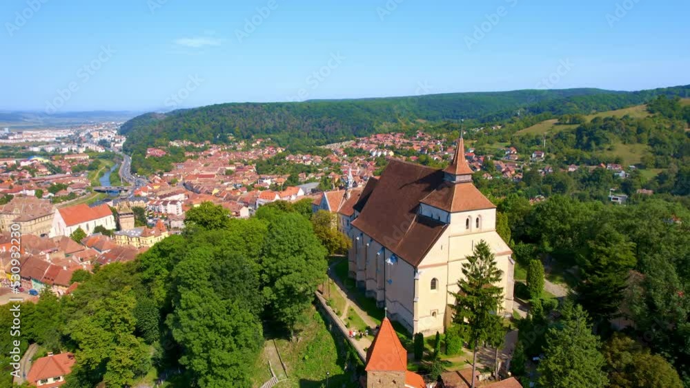 Aerial drone view of the Historic Centre of Sighisoara, Romania. Old buildings, Church on the Hill, surrounded by greenery Aerial drone view of the Historic Centre of Sighisoara, Romania. Old buildings, Church on the Hill, surrounded by greenery