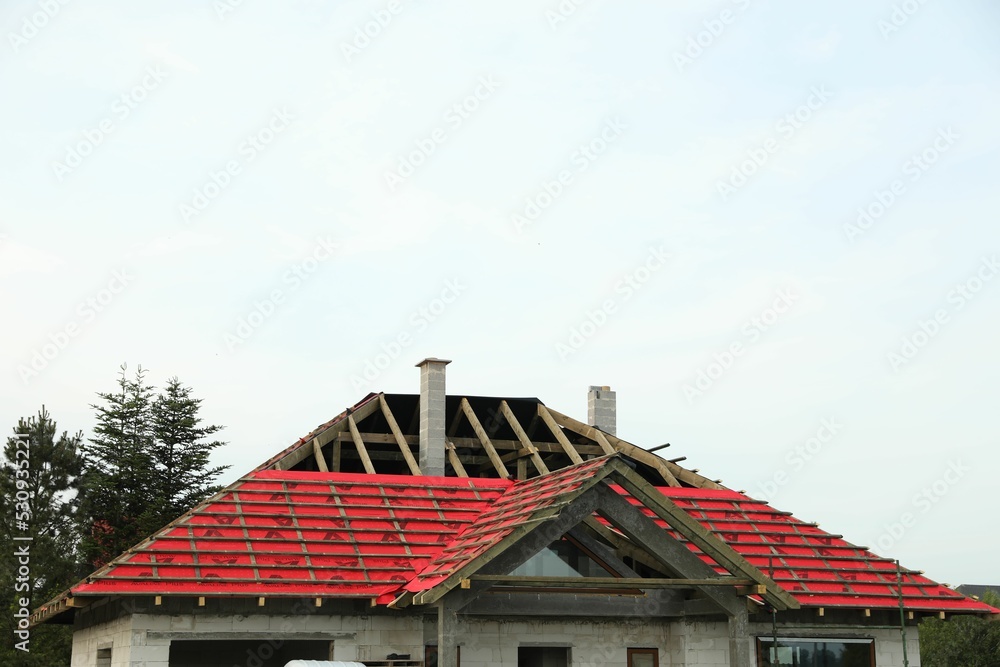 Roof of house under construction against sky Roof of house under construction against sky