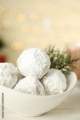 Bowl with tasty Christmas snowball cookies on wooden table, closeup