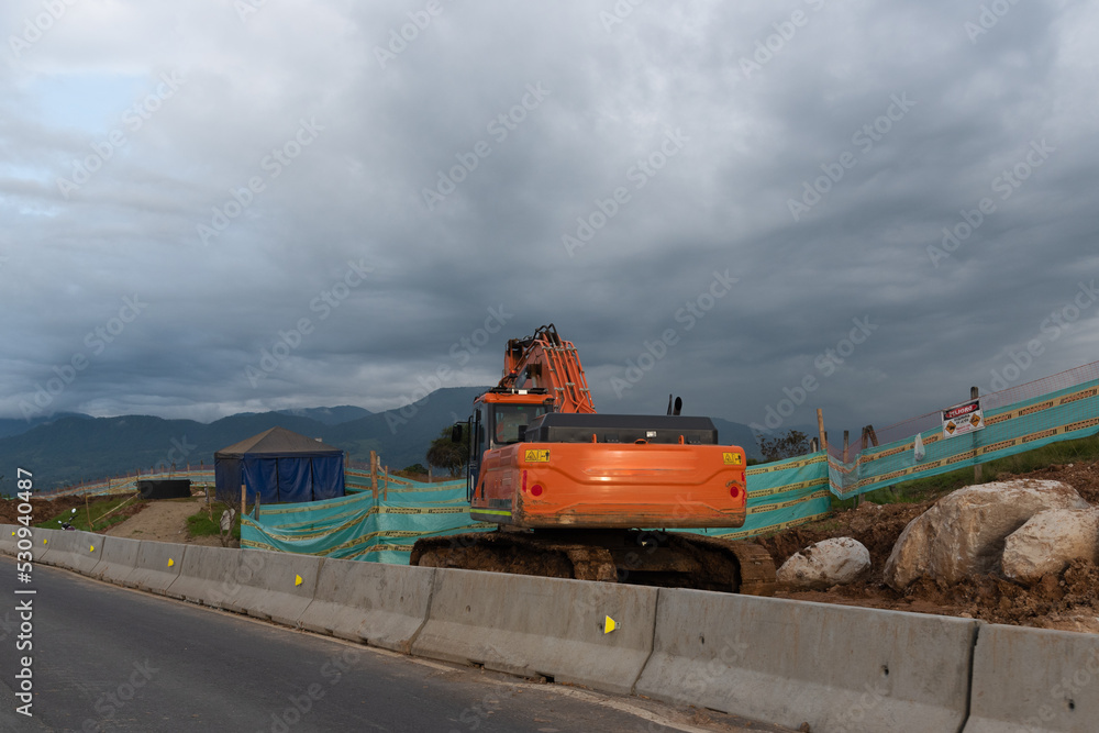 Excavator in a construction zone on the side of a Colombian highway.