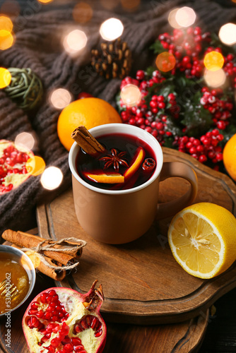 Mug of tasty mulled wine and ingredients on table
