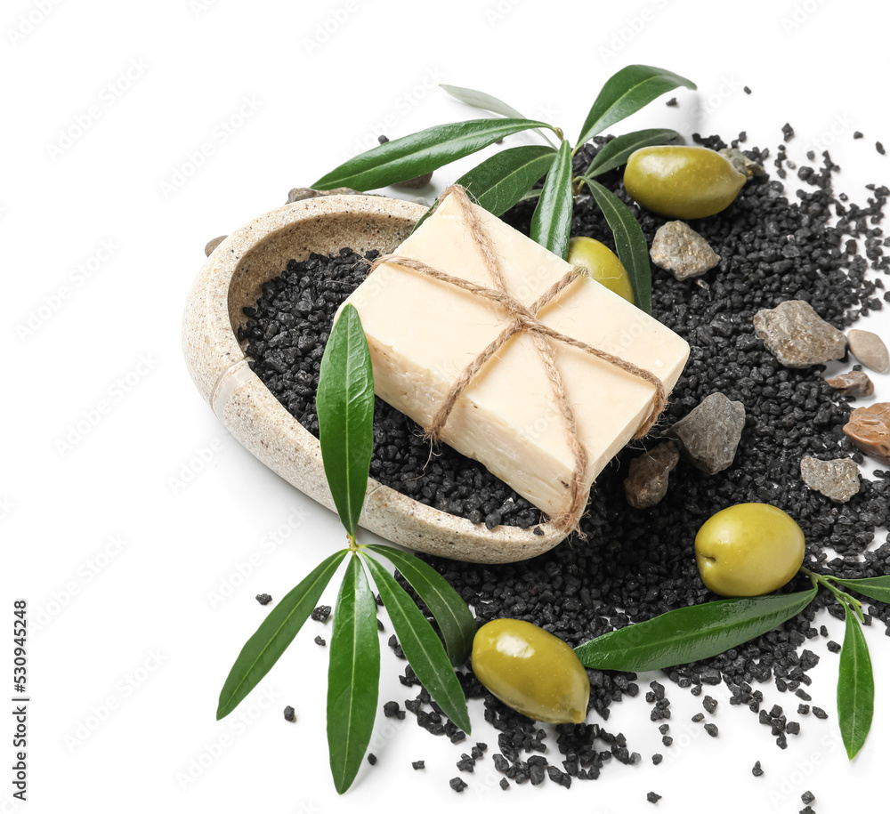 Composition with olive soap bar and green leaves on white background Composition with olive soap bar and green leaves on white background