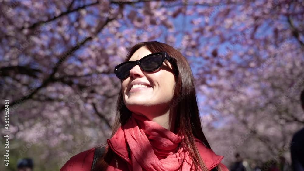 Spring. A woman walks in the park where the trees have blossomed with flowers. Spring. A woman walks in the park where the trees have blossomed with flowers.