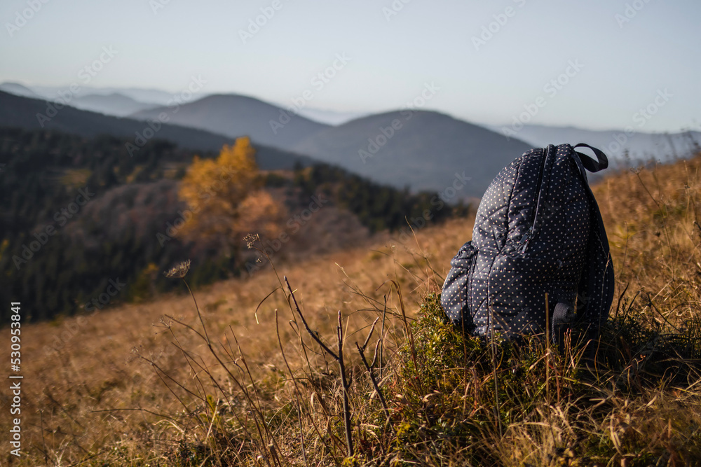 Tourist backpack on ground in front of mountains landscape