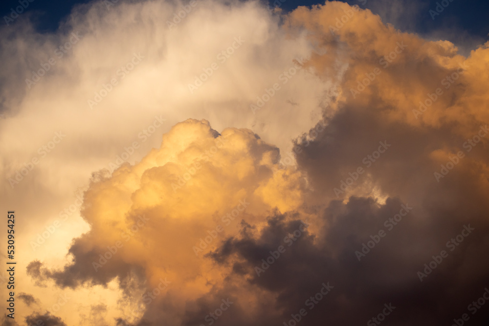 Richly multicolored white and yellow puffy clouds at sunset