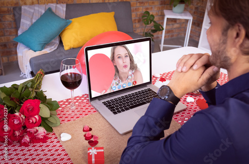 Caucasian couple making valentines date video call the woman on laptop screen blowing kiss