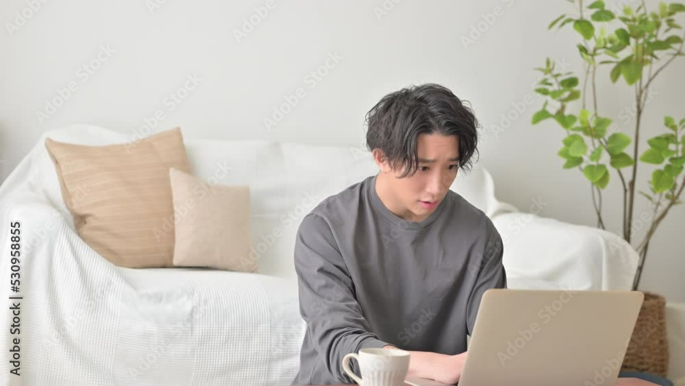 リビングで返事を見て驚く男性