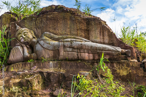 The old Buddha carved on big boulder in Laos.