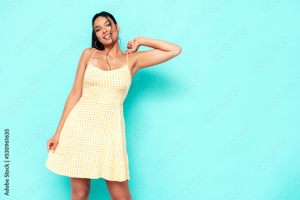 Young beautiful smiling female in trendy summer dress clothes. Sexy carefree woman posing near blue wall in studio. Positive model having fun and going crazy. Cheerful and happy Young beautiful smiling female in trendy summer dress clothes. Sexy carefree woman posing near blue wall in studio. Positive model having fun and going crazy. Cheerful and happy
