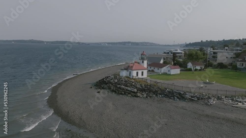 Slow aerial push towards the Alki Point Lighthouse in Seattle, Washington. photo