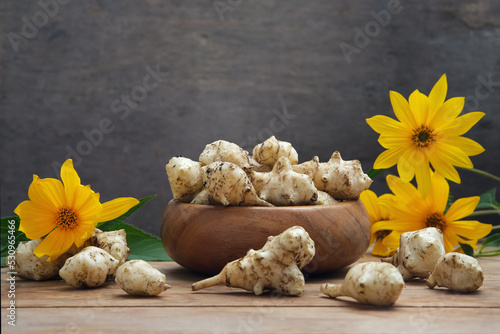 Roots, flowers and leaves of fresh organic topinambur or jerusalem artichoke Helianthus tuberosus. Tubers of sunroot, sunchoke or earth apple. Diabetic friendly food vegetable with inulin.