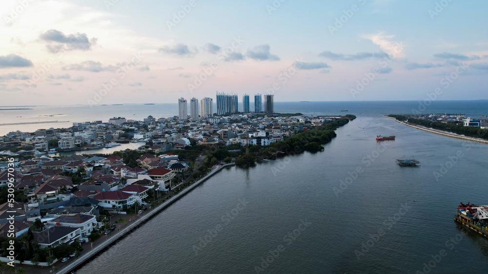Aerial view of the Bright spring cityscape of Pluit port. Colorful sunset view of Jakarta, Indonesia. Beautiful Jakarta seascape. Traveling concept background. 