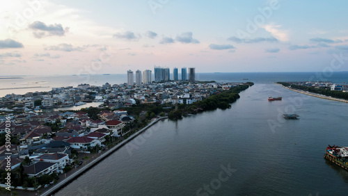 Aerial view of the Bright spring cityscape of Pluit port. Colorful sunset view of Jakarta, Indonesia. Beautiful Jakarta seascape. Traveling concept background. 