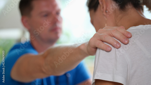 Doctor puts sympathetic hand on clinic woman shoulder