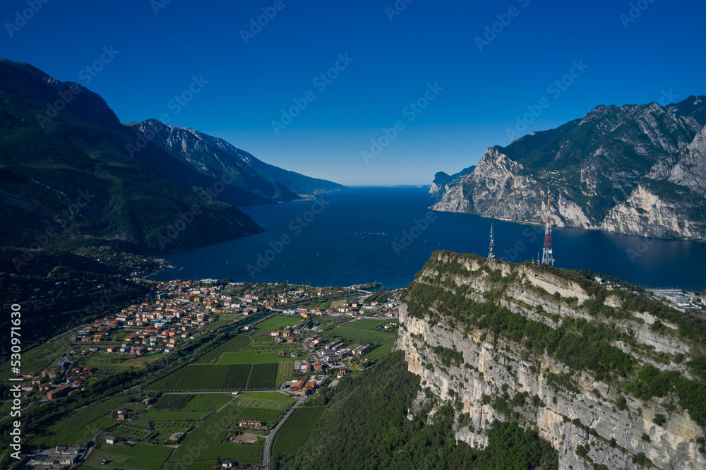 Obraz premium Panorama of the gorgeous Lake Garda surrounded by mountains in Riva del Garda, Italy. Italian Alps panoramic views of the Riva del Garda and lake Garda.