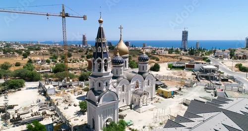 Aerial drone footage of the construction of Russian orthodox church Saint Nicholas in Limassol, Cyprus.360 close up of golden dome, bell tower, cross of religious russian architecture from above. photo