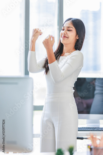 Free Download Millennial Asian happy successful professional female businesswoman standing smiling holding raising fists up celebrating after job agreement achievement goal deal done in company office workstation - GFXLoad