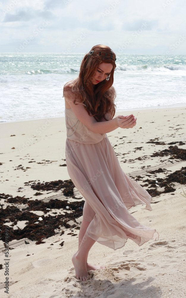full length portrait of beautiful young woman with long hair wearing simple dress flowing in wind, elegant standing pose. ocean beach background with golden sunset lighting. full length portrait of beautiful young woman with long hair wearing simple dress flowing in wind, elegant standing pose. ocean beach background with golden sunset lighting.
