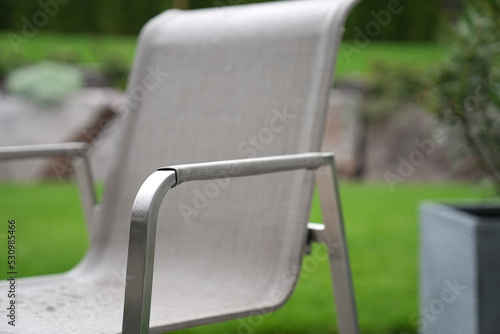Stuhl im Garten mit grüner Wiese im Hintergrund